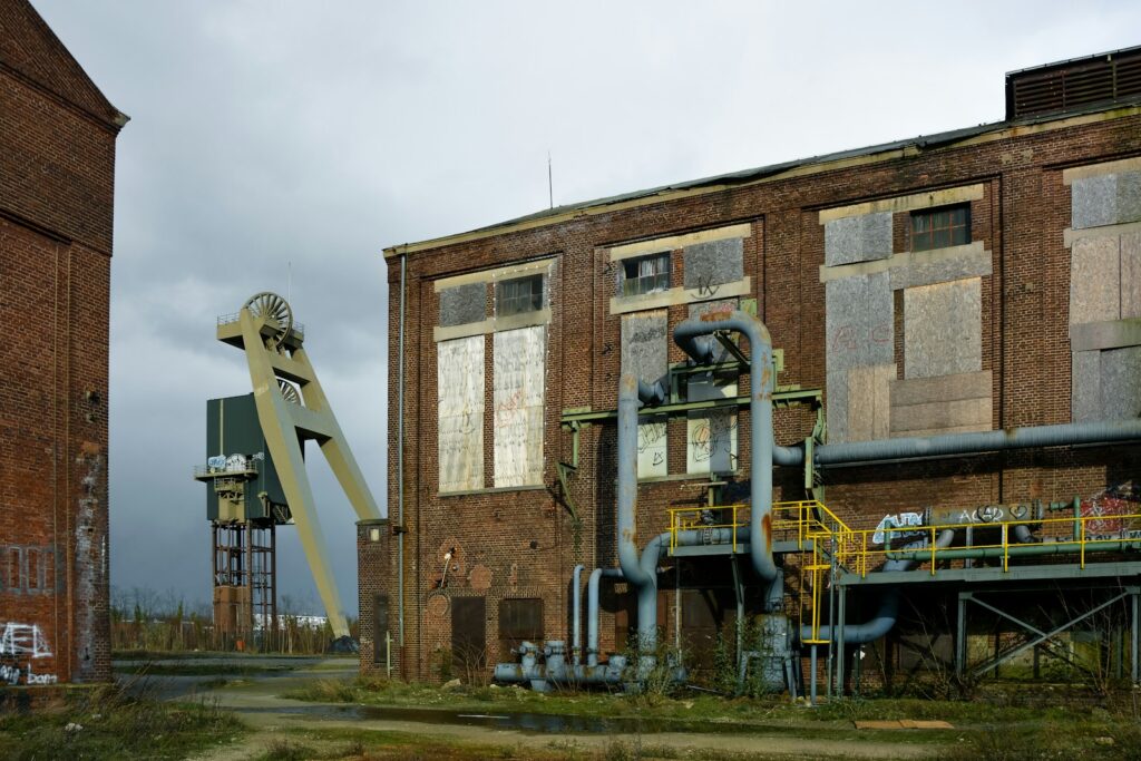 An old factory building with a crane in front of it